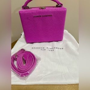 Brandon Blackwood mini trunk bag. Purple. Packaged crossbody strap. Dust bag.